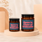 Two amber glass candles with black lids read "Open in Case of Bridezilla."