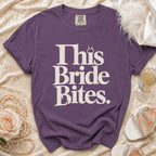 Purple t-shirt with "This Bride Bites." text and diamond ring graphic.