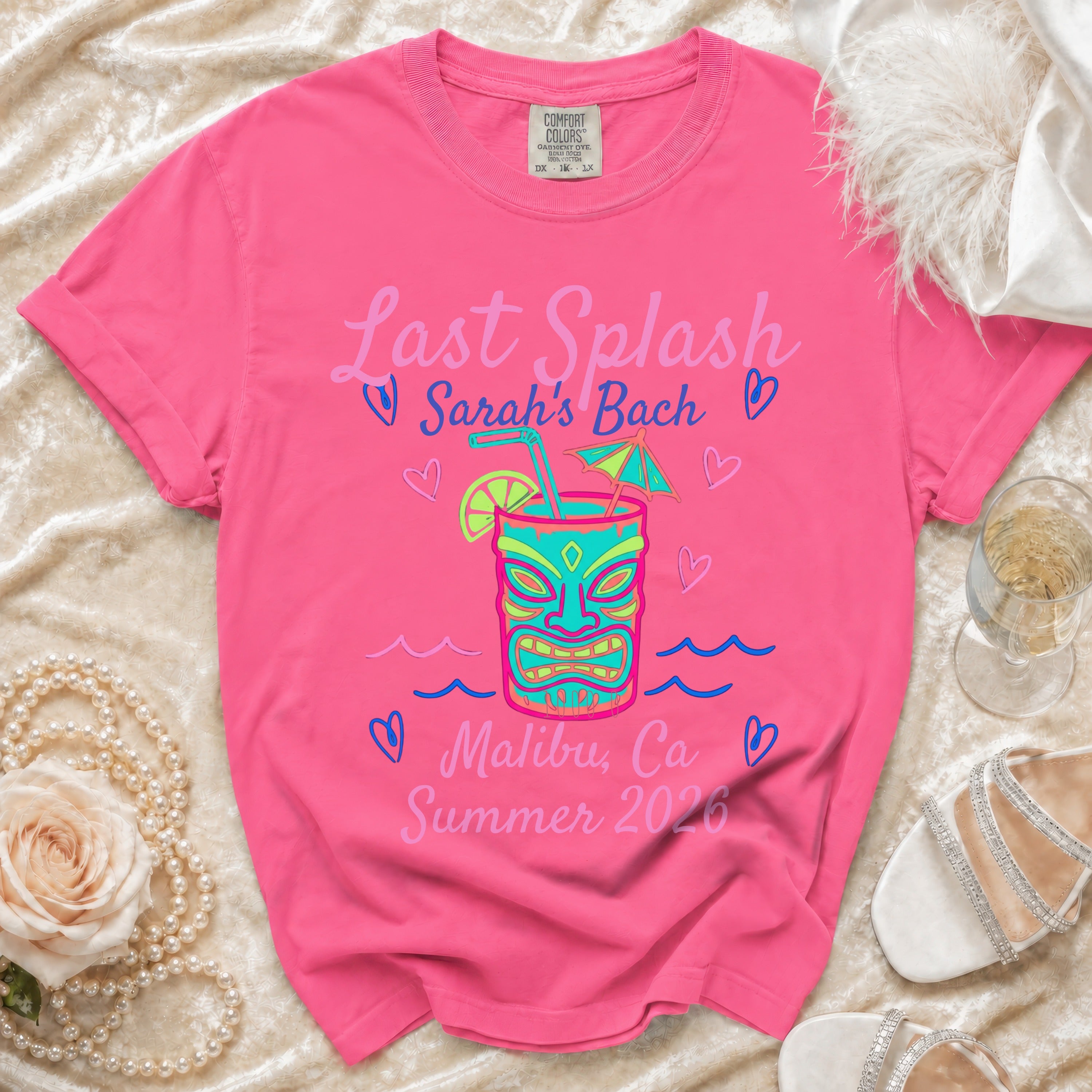 Pink t-shirt with "Last Splash Sarah's Bach Malibu, Ca Summer 2026" and tiki mask graphic.