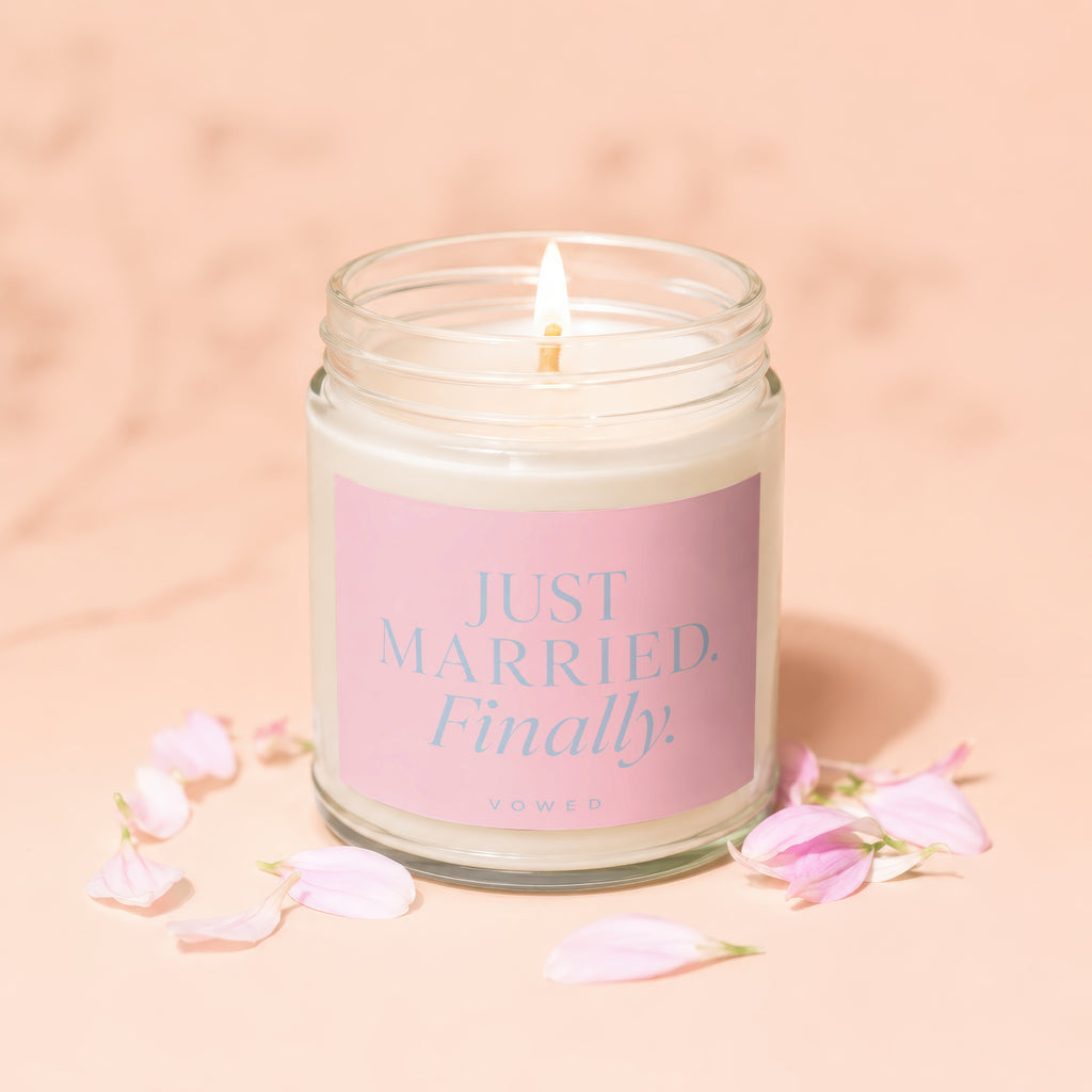 Glass jar candle with "JUST MARRIED. Finally." printed on a pink label.