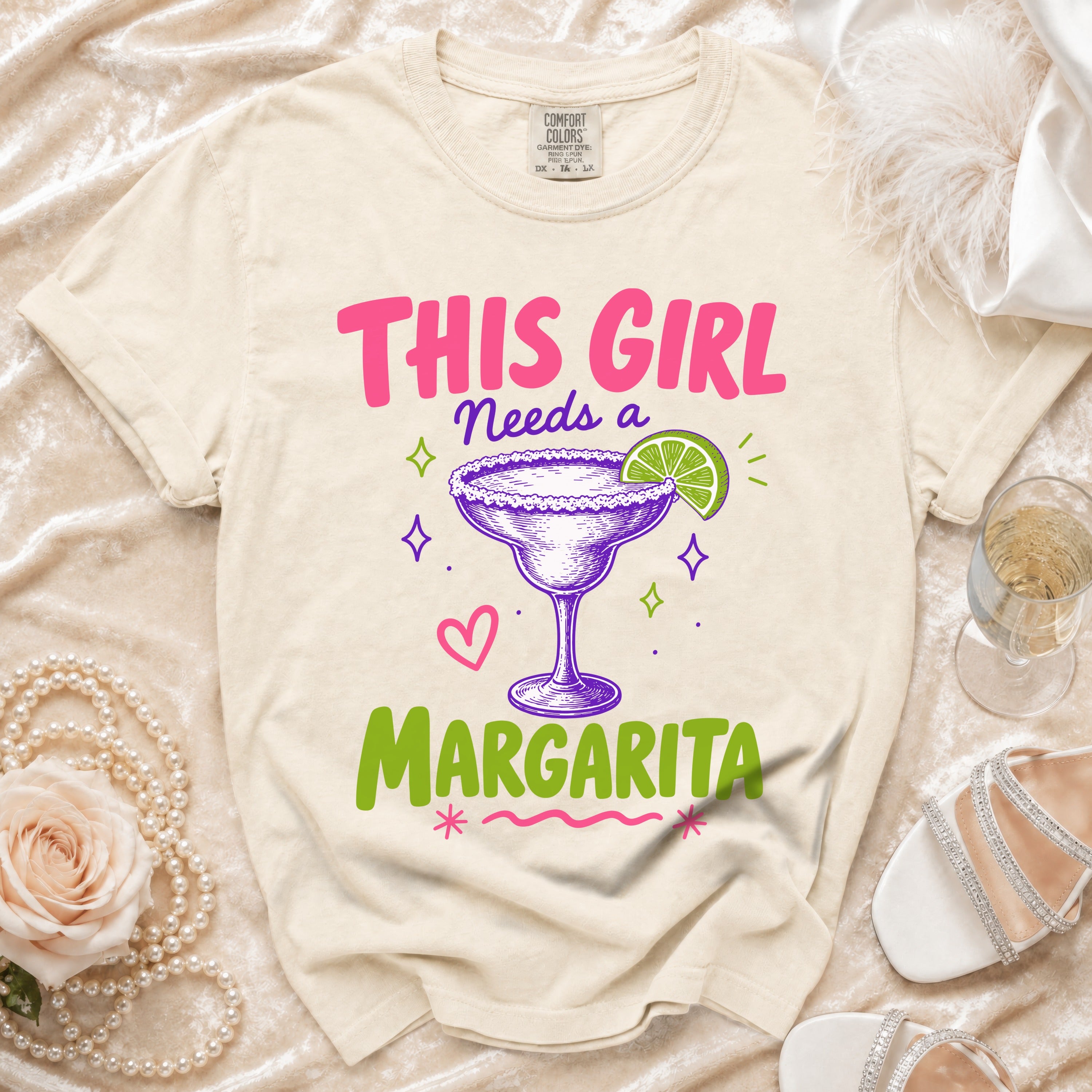 Cream t-shirt with "This Girl Needs a Margarita" graphic and margarita glass.