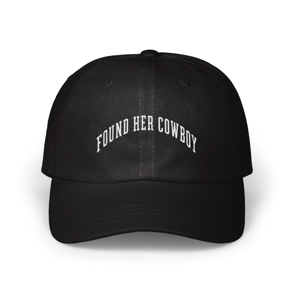 A black baseball cap with white embroidered text reading "FOUND HER COWBOY" arched across the front.