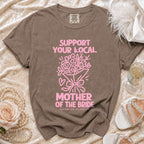 Brown comfort colors t-shirt with pink text "Support Your Local Mother of the Bride" and bouquet graphic.