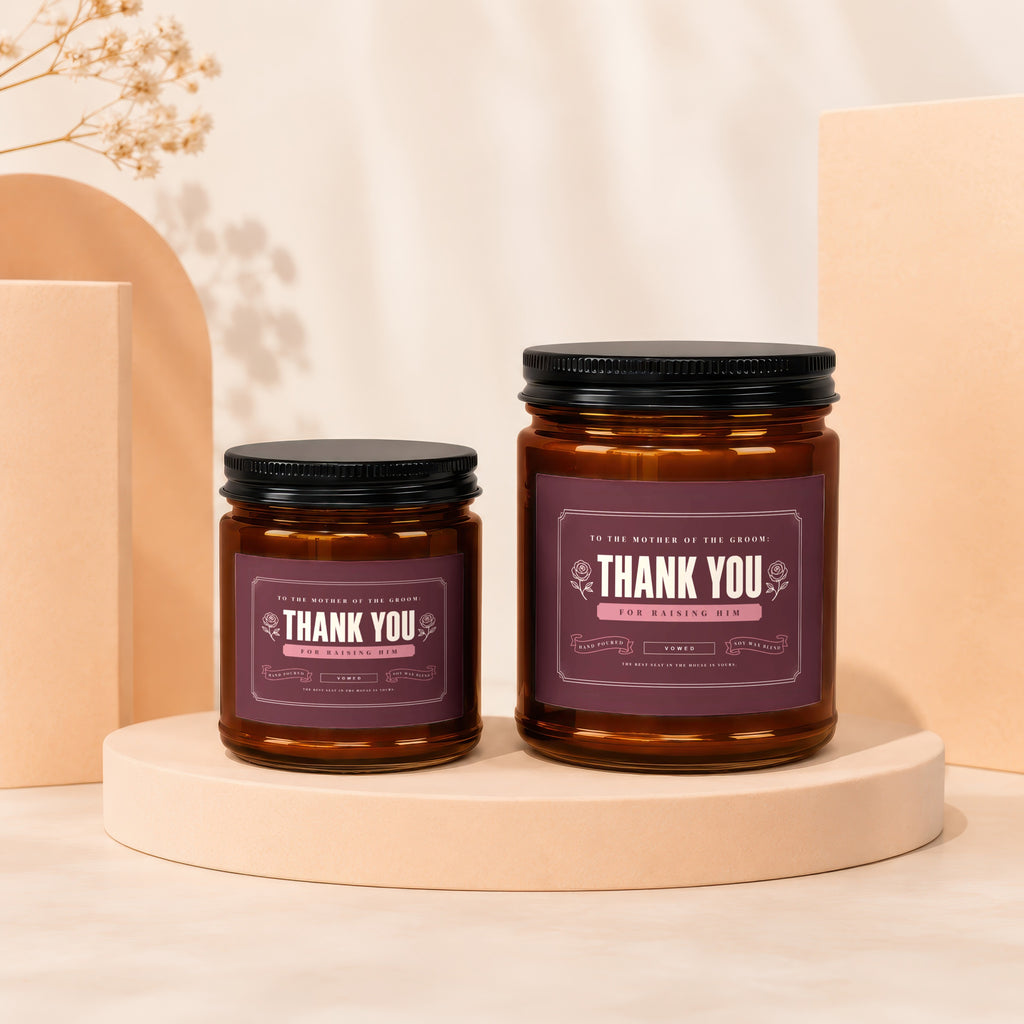 Two amber glass candles with "Thank You for Raising Him" labels on purple backgrounds.