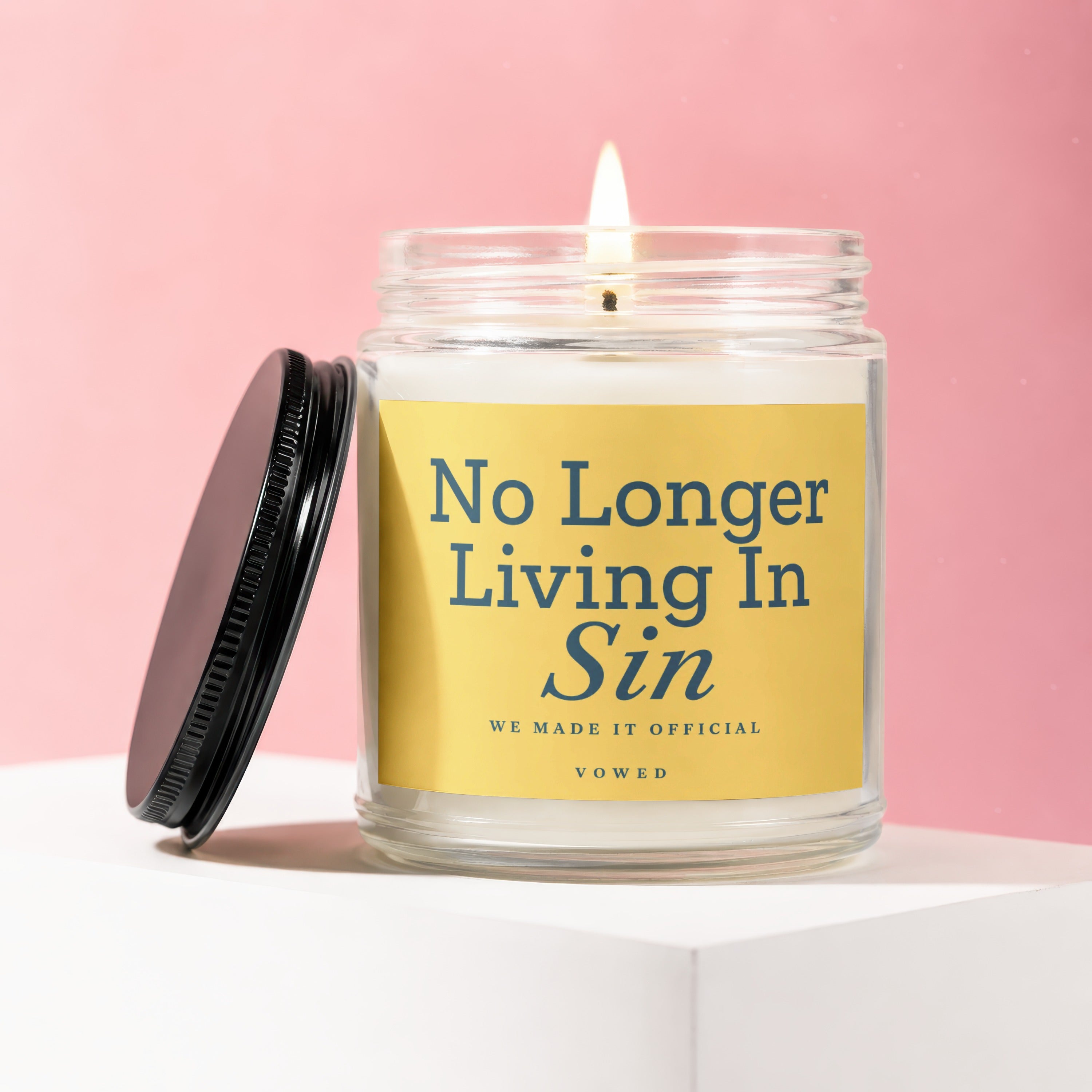 Glass jar candle with yellow label reading "No Longer Living In Sin WE MADE IT OFFICIAL VOWED".