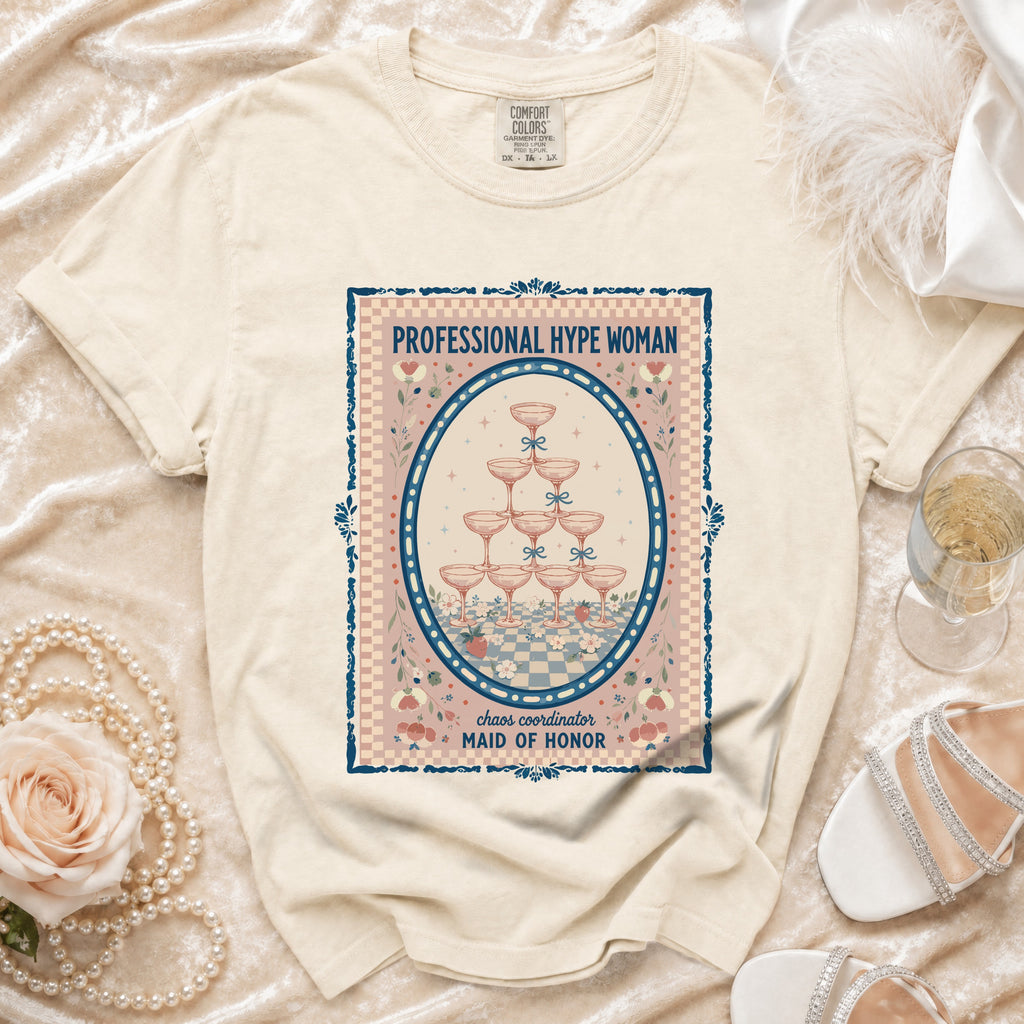 Cream t-shirt with oval graphic: "PROFESSIONAL HYPE WOMAN, chaos coordinator MAID OF HONOR".