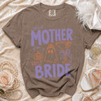 Brown Comfort Colors t-shirt with "Official Mother of the Bride" in purple and orange graphics.