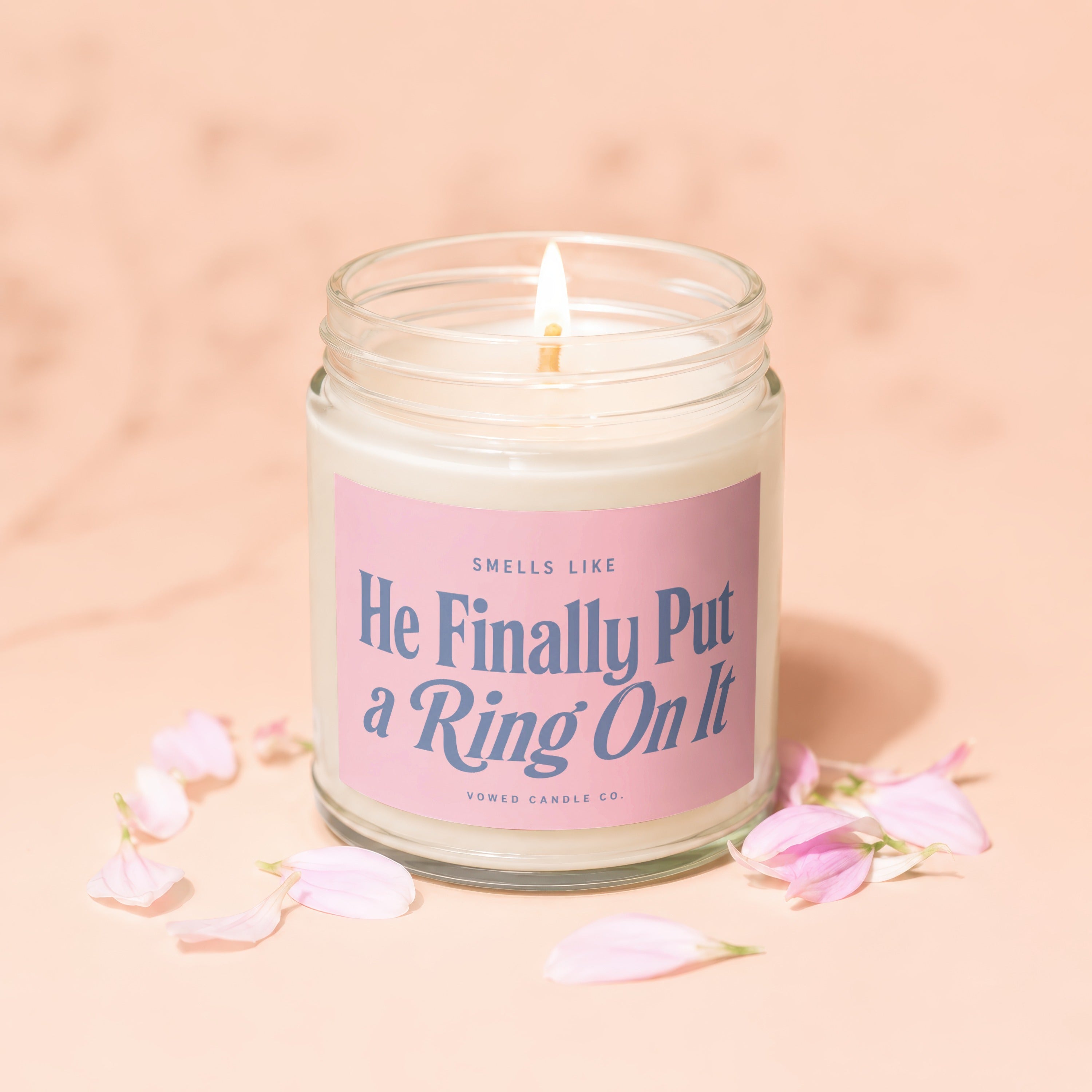 Candle with pink label reading "Smells Like He Finally Put a Ring On It".