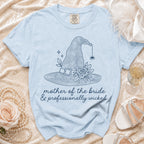 Light blue t-shirt with witch hat graphic and text "mother of the bride & professionally wicked".