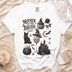 White t-shirt with "Mother of the Bride (And Still Keeping It Spooky)" graphic.