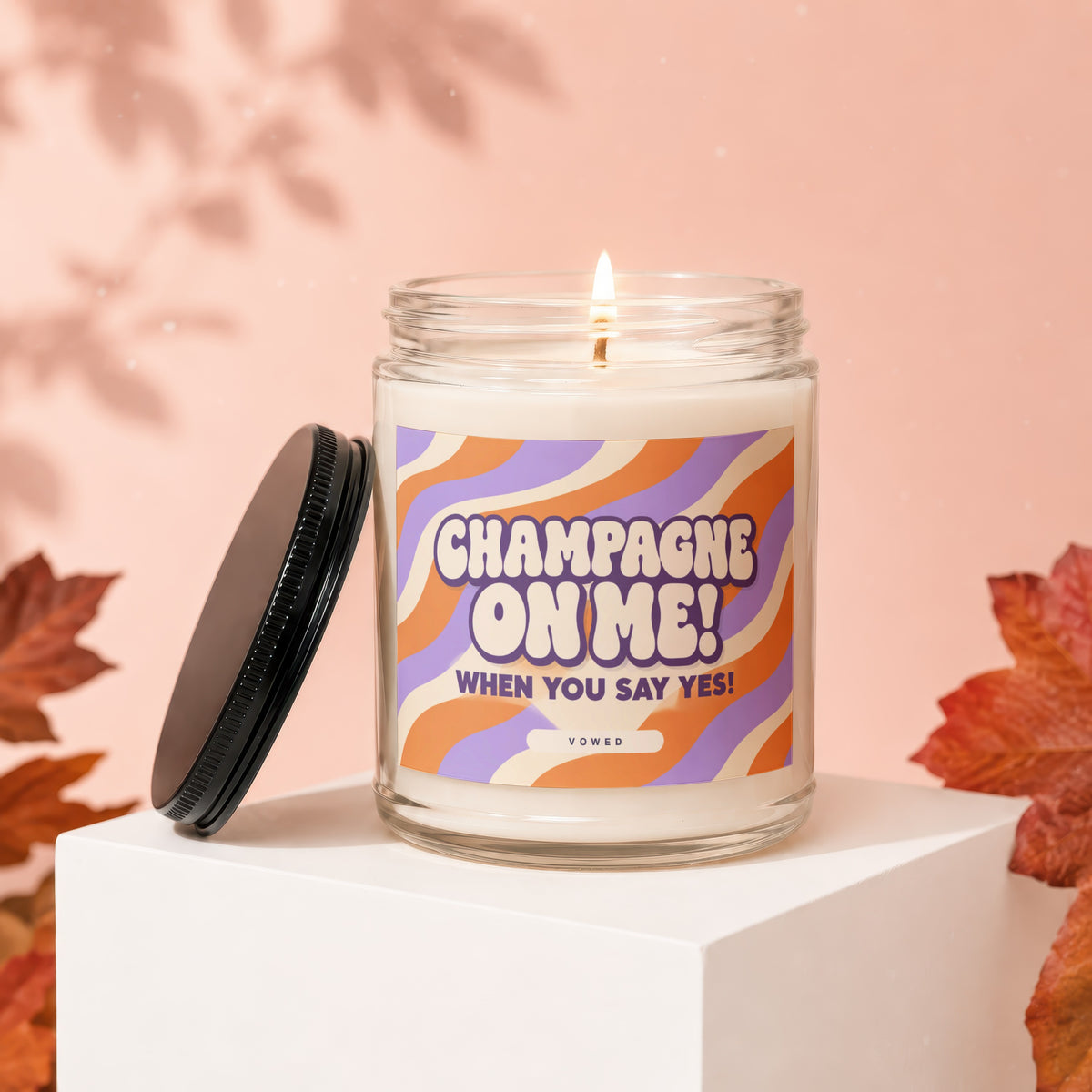Candle with "Champagne On Me! When You Say Yes!" text, lit flame.