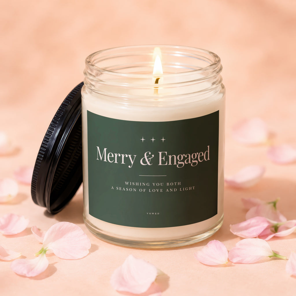Candle with "Merry & Engaged" text, surrounded by pink petals.