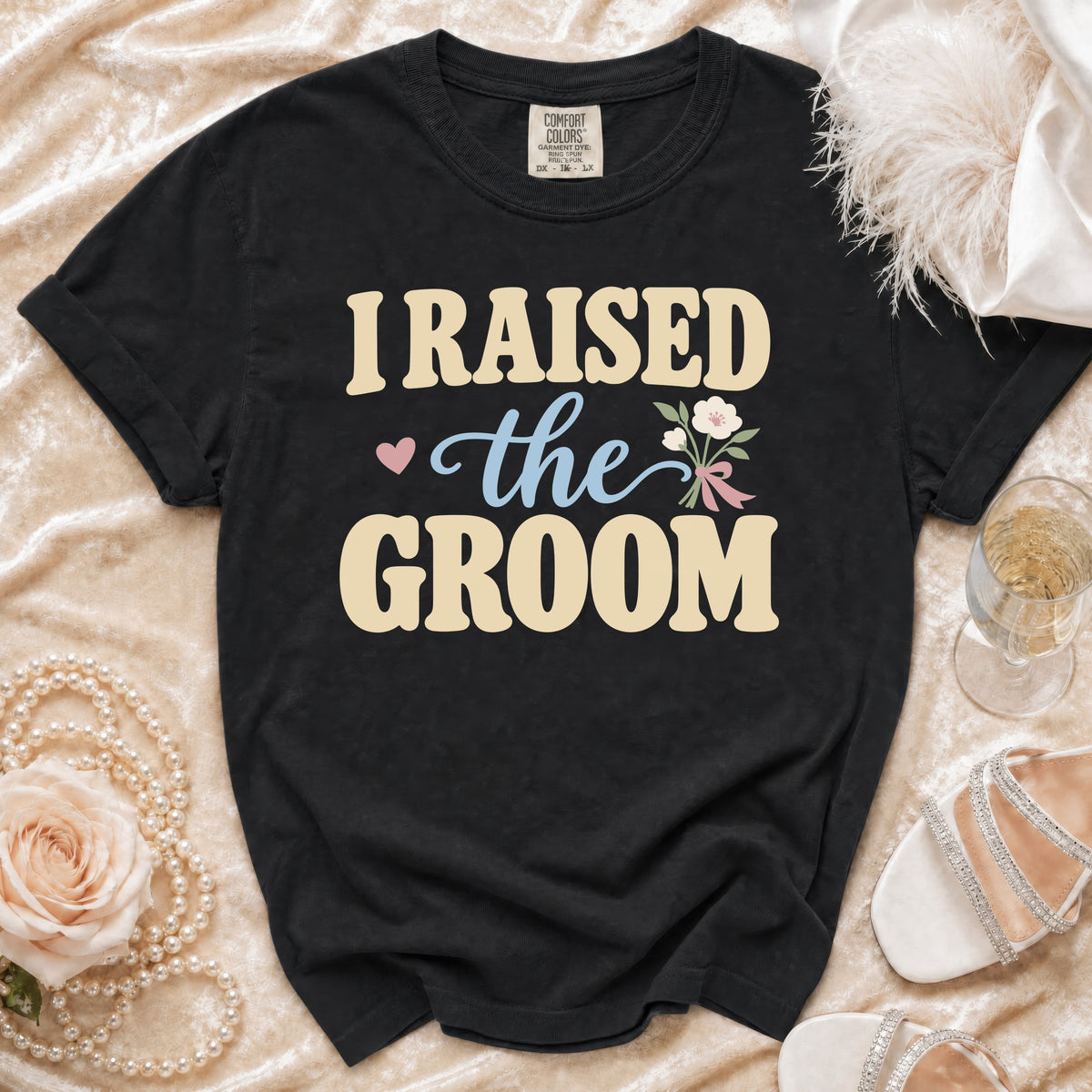 Black t-shirt with "I RAISED the GROOM" graphic and floral accent.