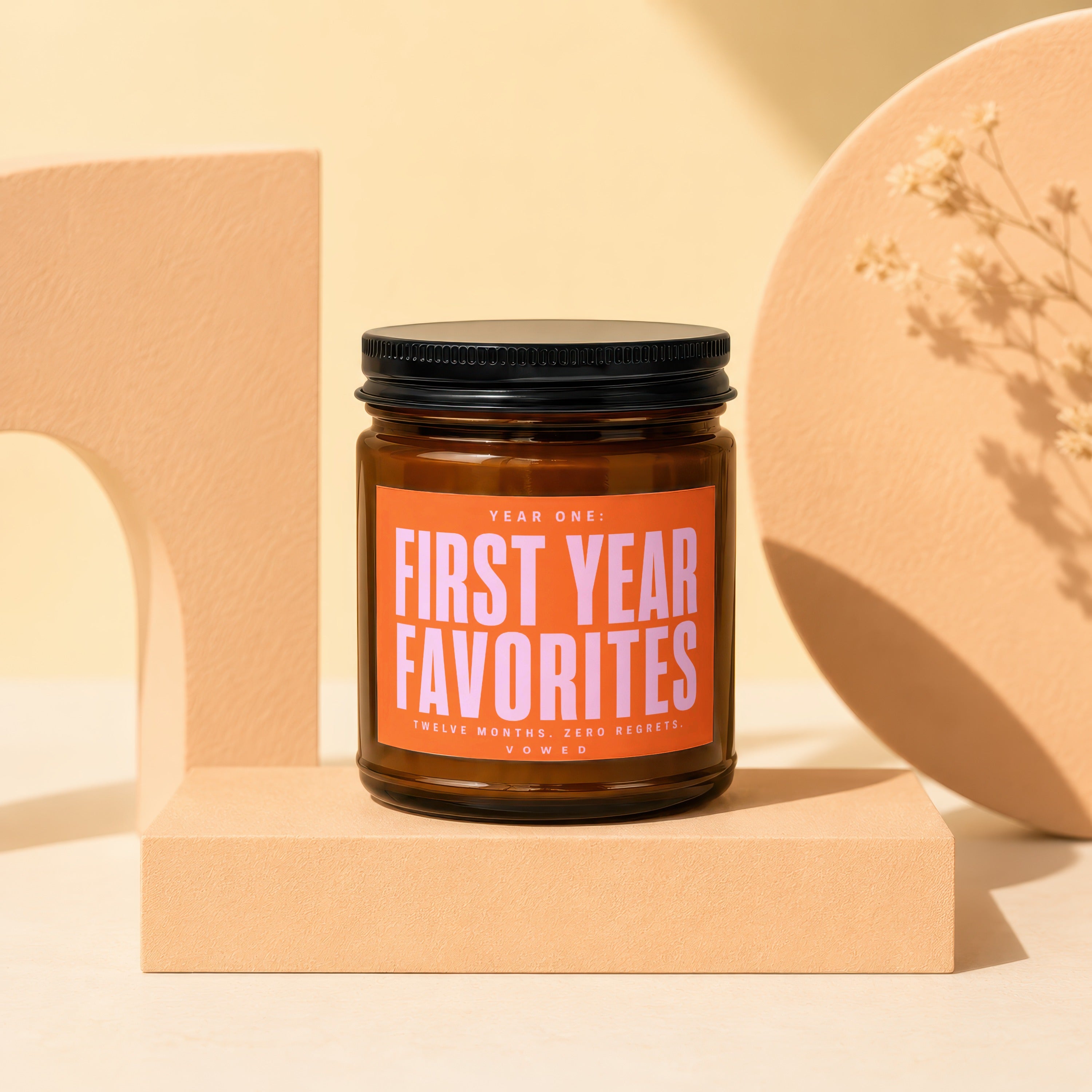 Brown candle with orange label reading "First Year Favorites Twelve Months. Zero Regrets. VOWED."
