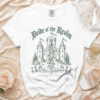 White t-shirt with a green graphic featuring a castle, a sword, roses, and bachelorette text.