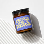Amber jar candle with blue label reading "Ride or Die, Now With a Dress Code".