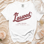 A white t-shirt featuring burgundy text that reads Lassoed for life, The Bride, Fort Worth, 2027.