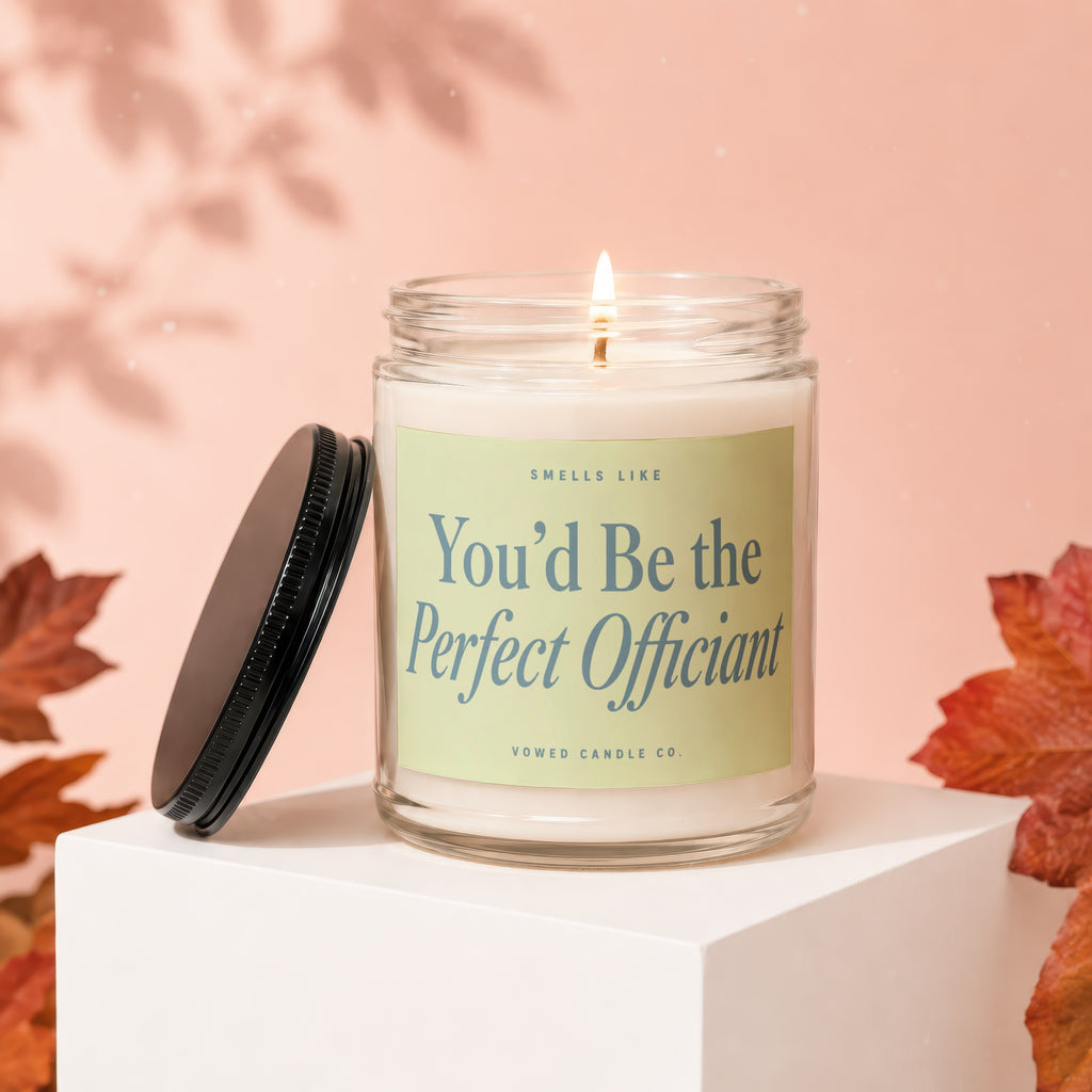 Lit candle with "You'd Be the Perfect Officiant" text on a pale green label.