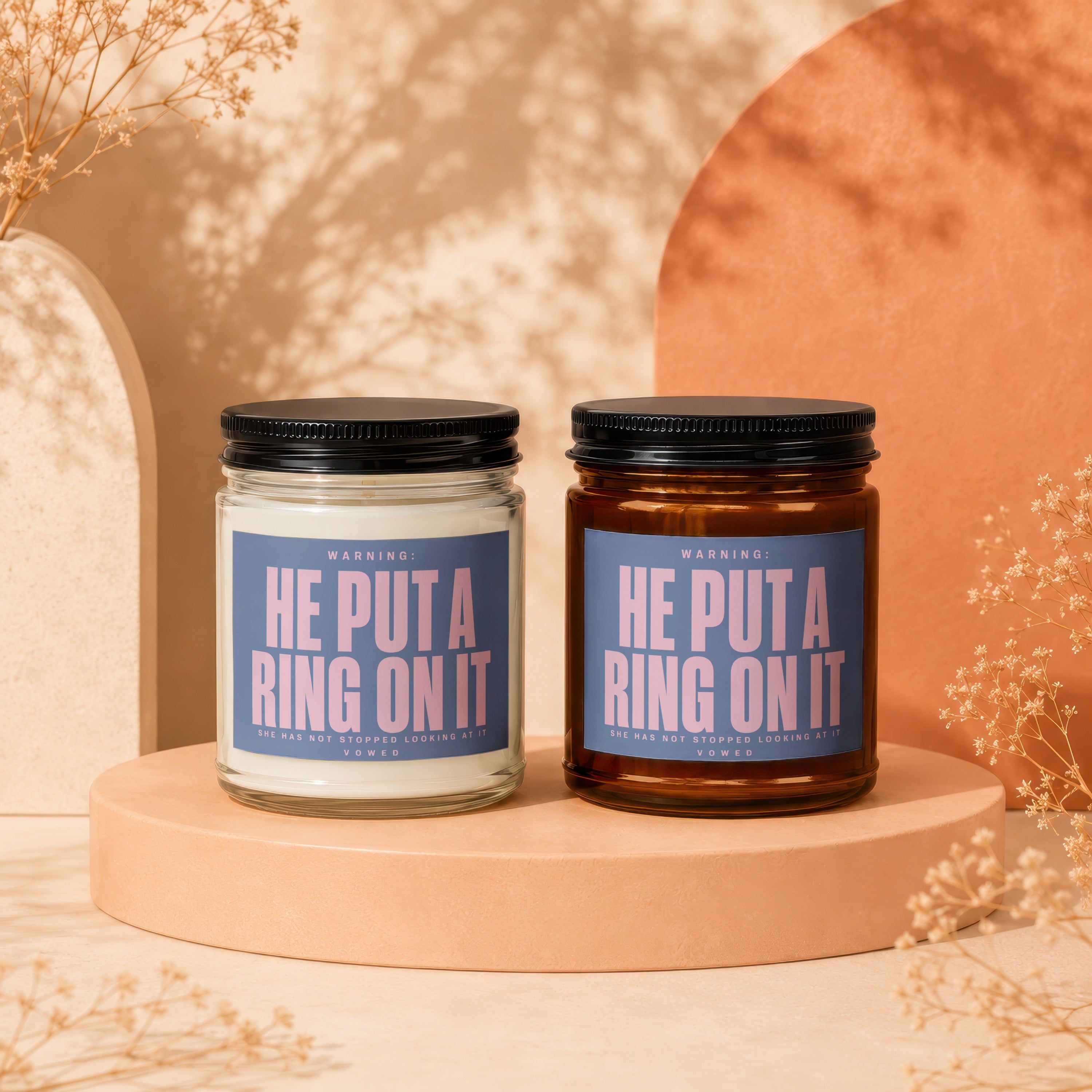 Two candles labeled "He Put A Ring On It" shown in a staged setting.