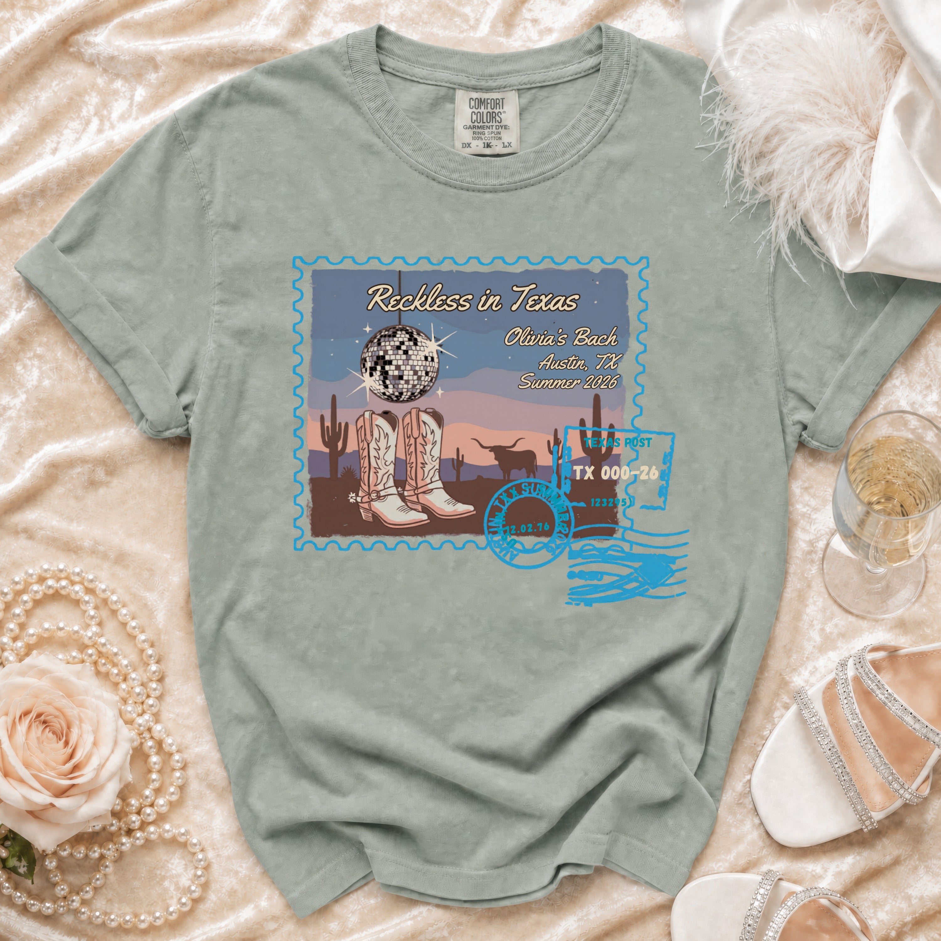T-shirt with "Reckless in Texas" design featuring cowboy boots, disco ball, and Texas postmark.