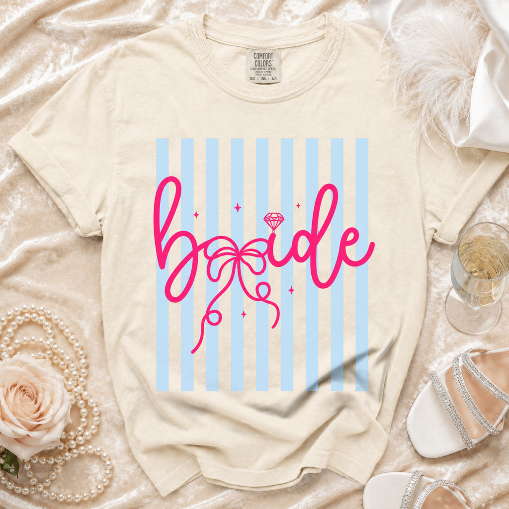 Cream t-shirt with pink "bride" graphic on light blue stripes.