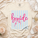Cream t-shirt with pink "bride" graphic on light blue stripes.