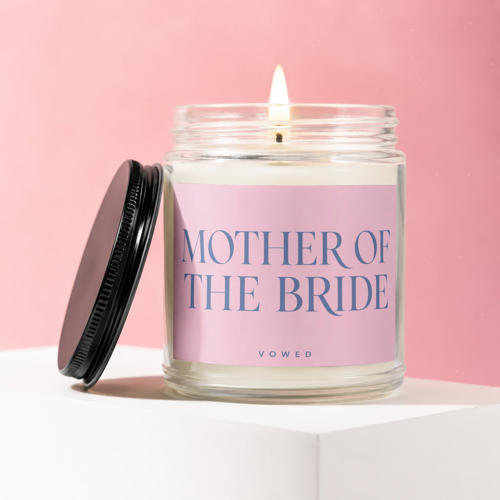 Candle labeled "Mother of the Bride" with lid ajar on a white pedestal.