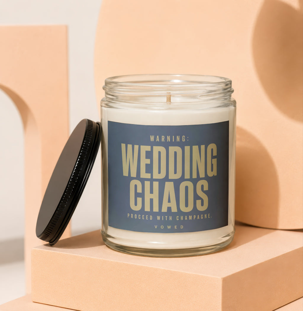 Glass candle with "Wedding Chaos Proceed with Champagne" label, lid off.