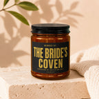 Amber jar candle with black lid, "The Bride's Coven" text, admission by invitation only.