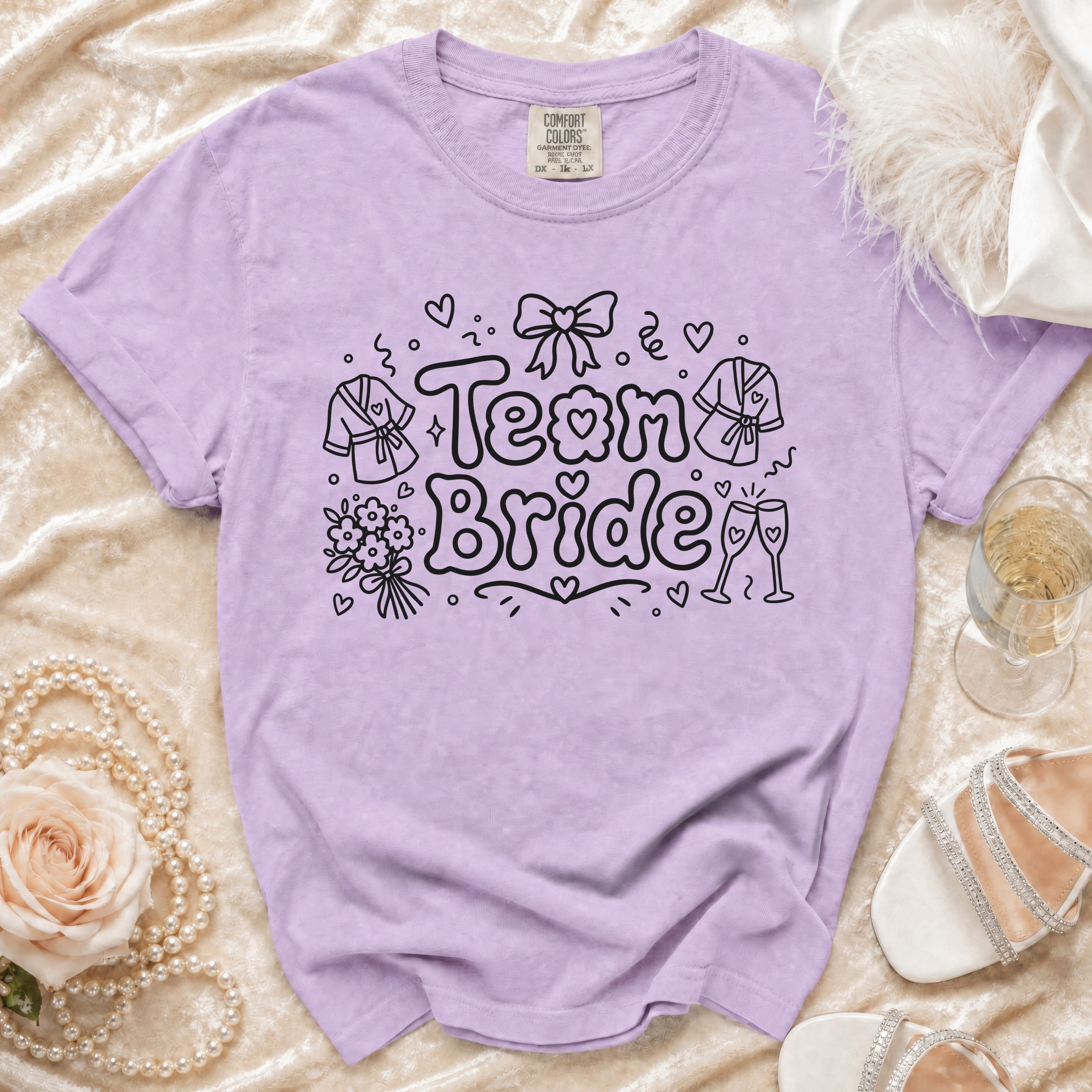 Lavender t-shirt with "Team Bride" graphic, shown with wedding accessories.