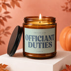 Brown glass candle with "OFFICIANT DUTIES" label and lit wick.