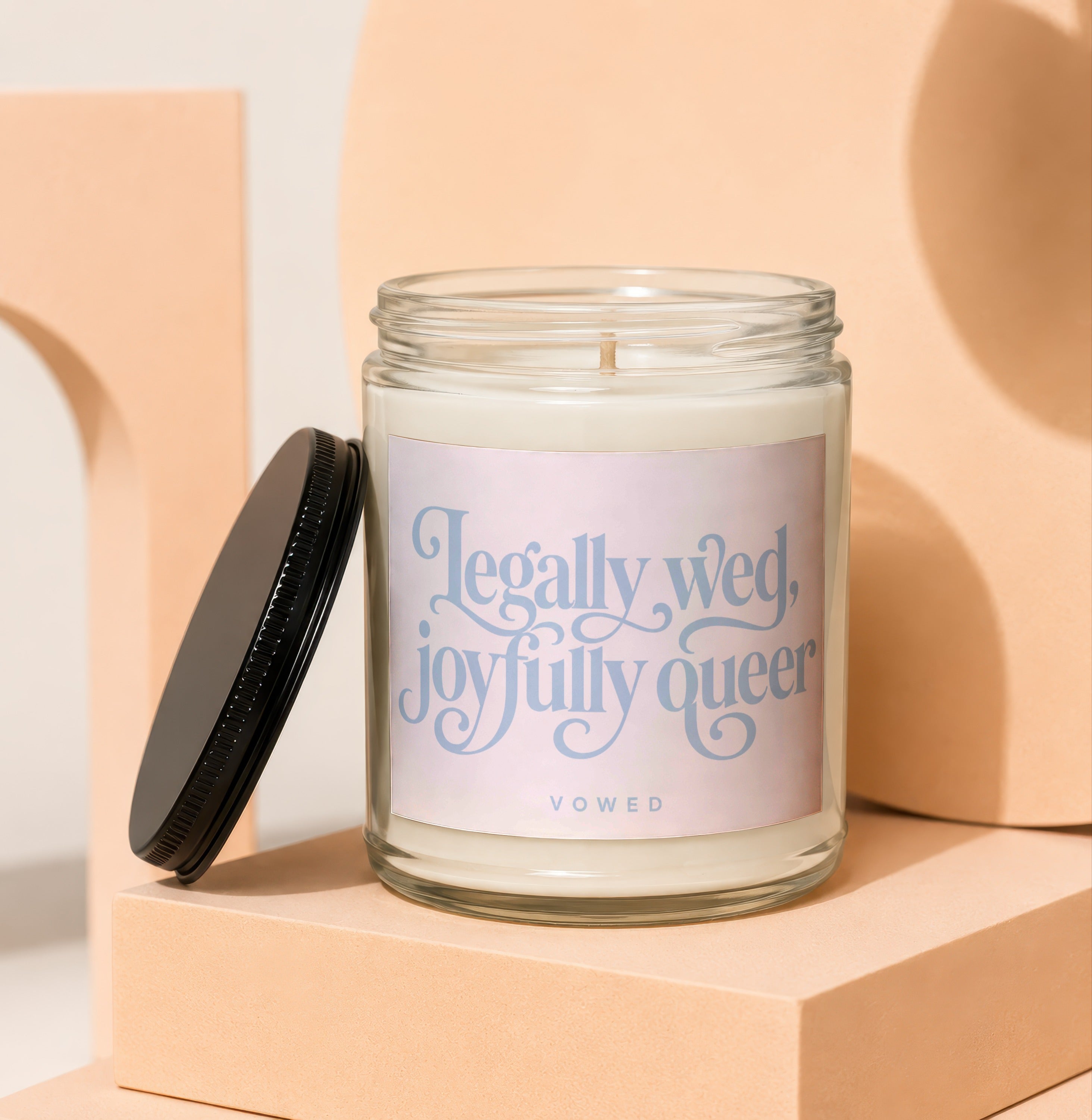 Glass candle with label reading "Legally wed, joyfully queer."