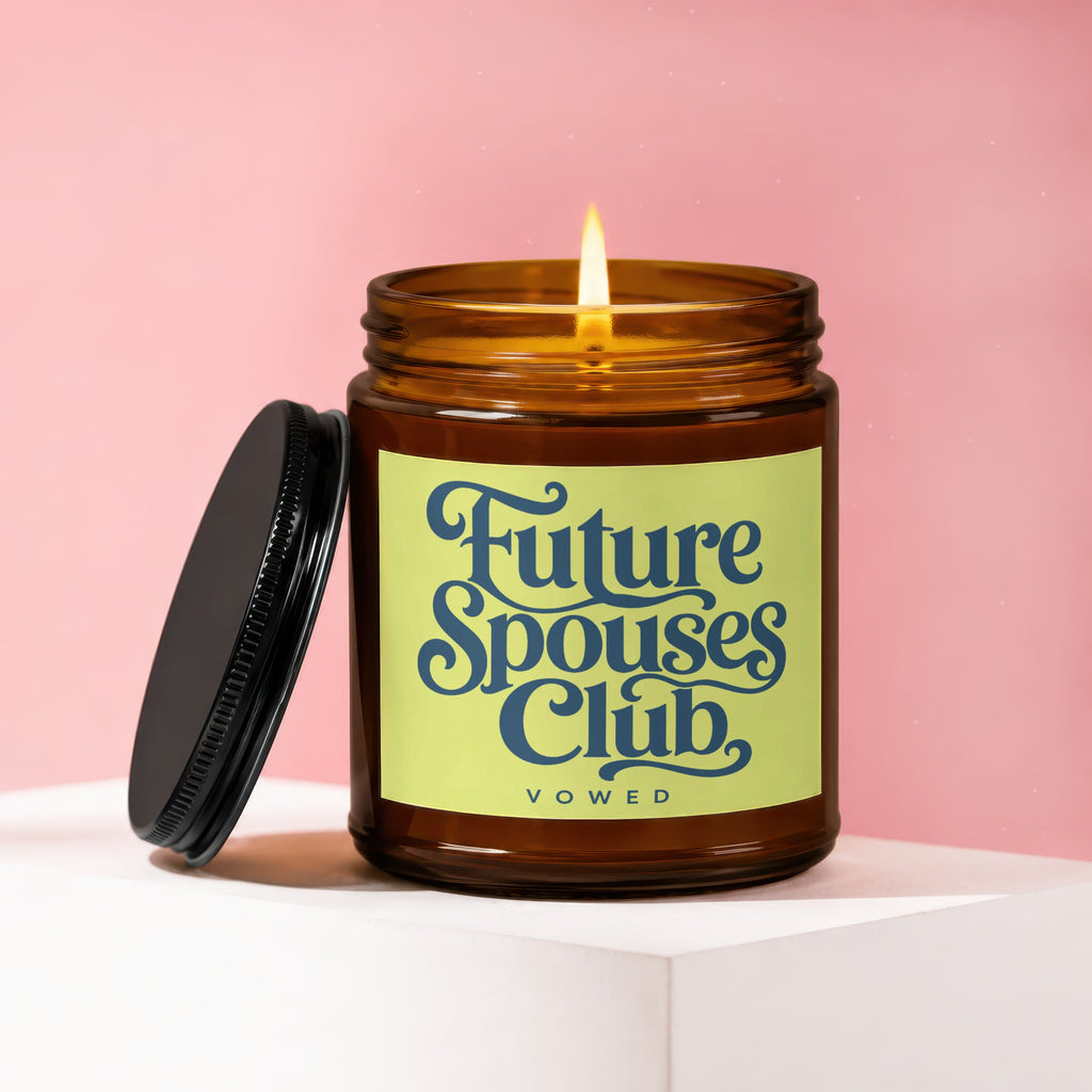 Amber jar candle with lit flame and black lid, labeled "Future Spouses Club, vowed."