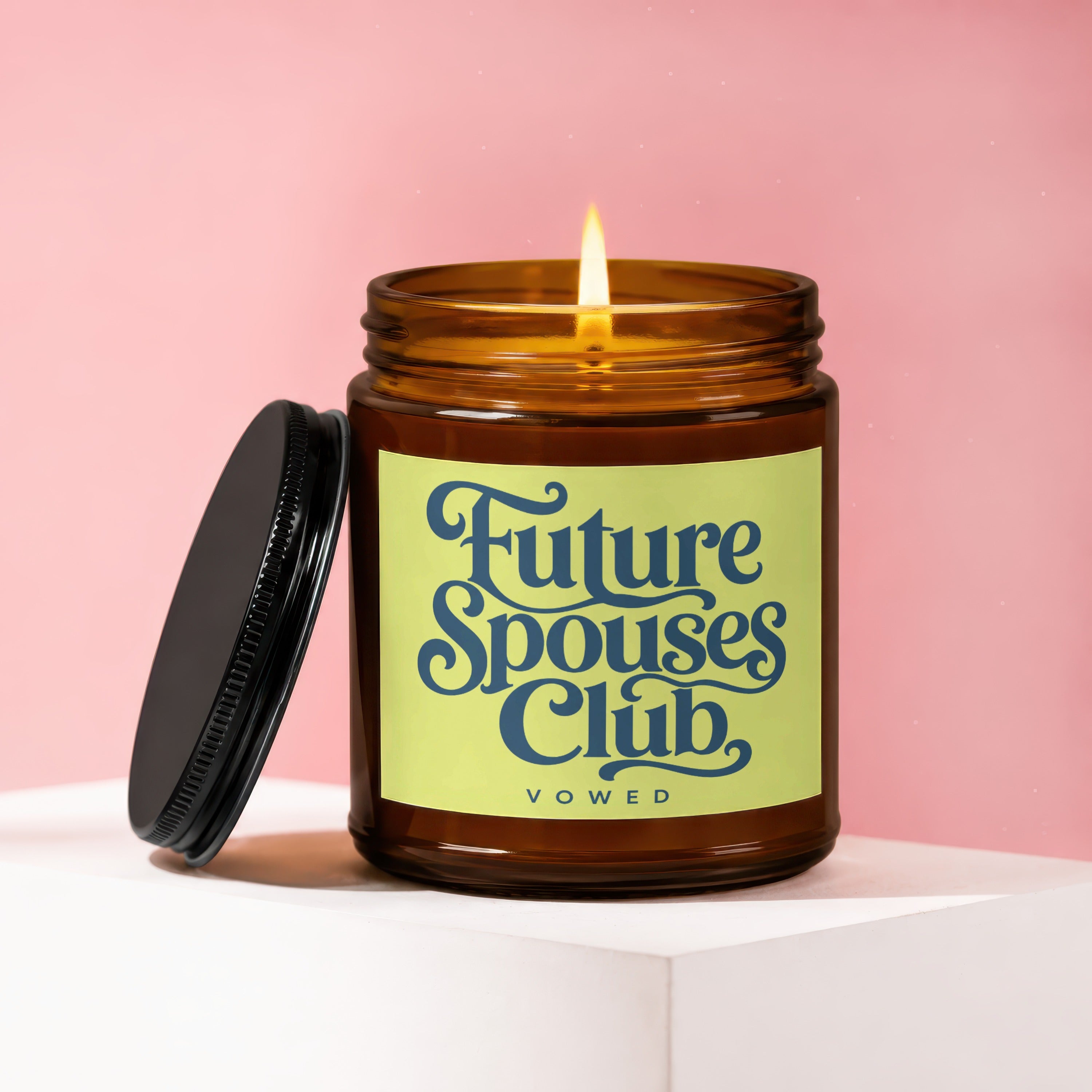 Amber jar candle with lit flame and black lid, labeled "Future Spouses Club, vowed."