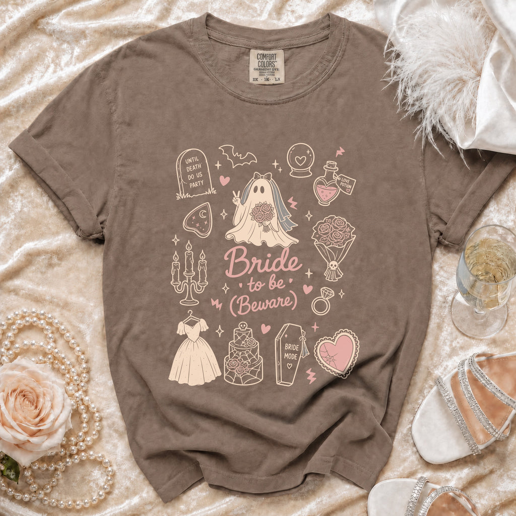 Brown Comfort Colors t-shirt with "Bride to be (Beware)" graphics and gothic bridal elements.