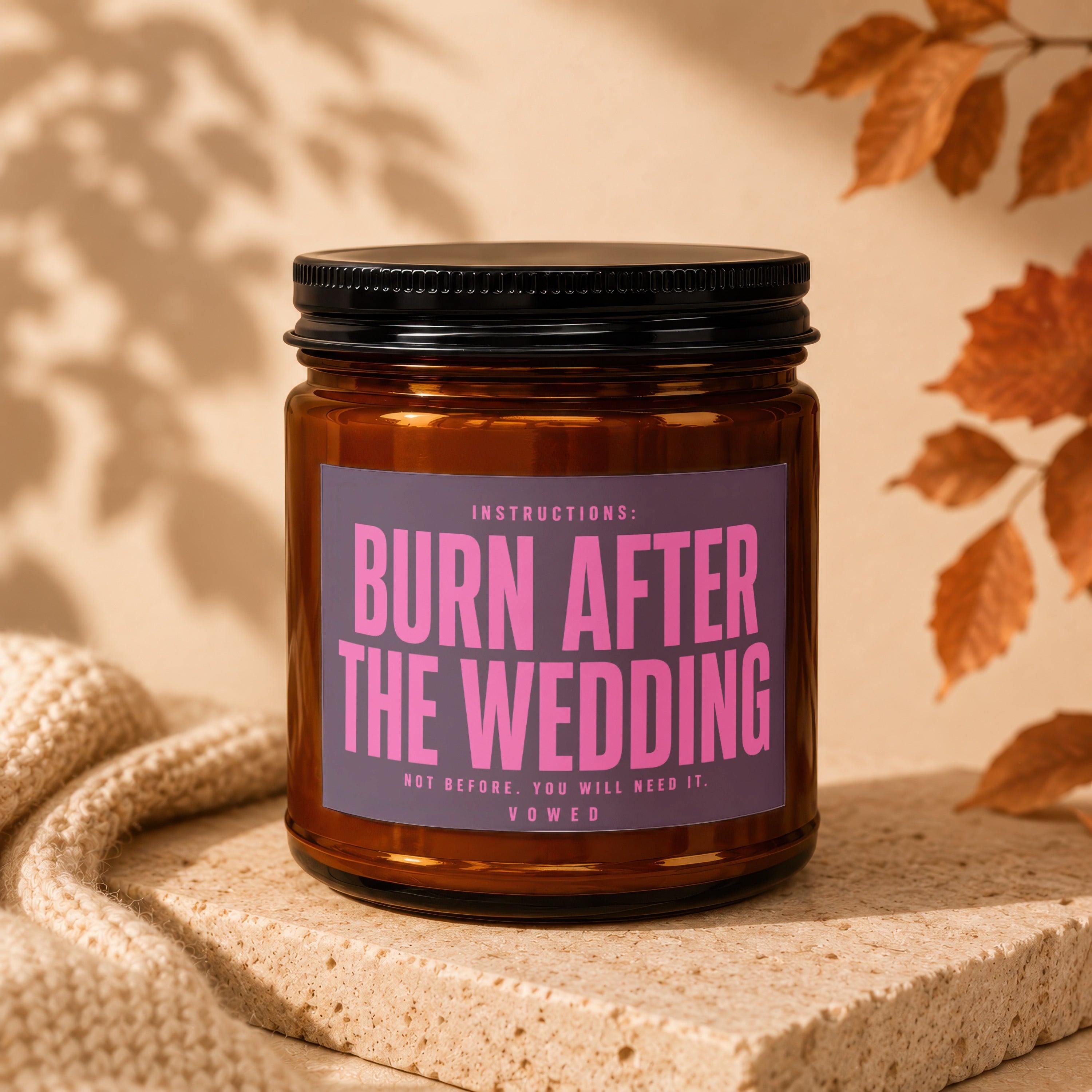 Amber candle in a jar labeled "Burn After The Wedding. Not Before. You Will Need It. Vowed."