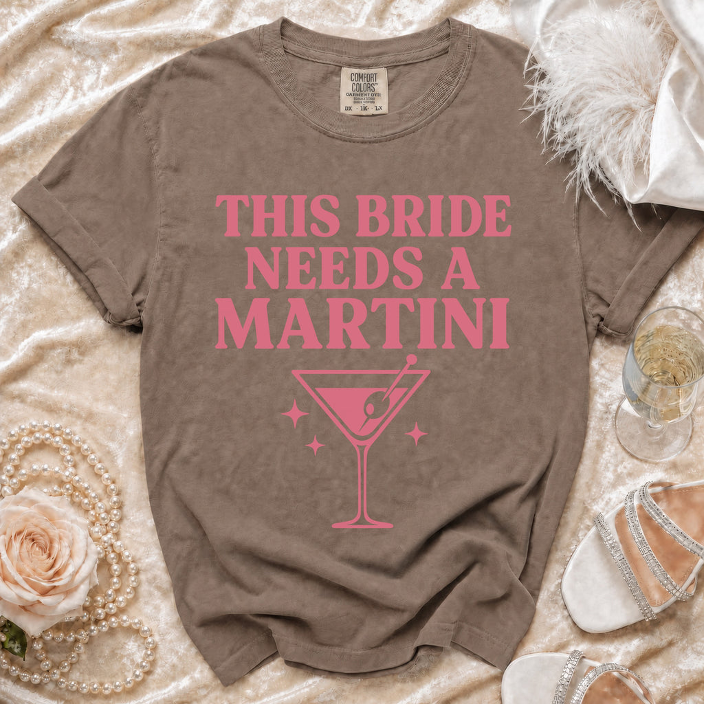 Brown t-shirt with pink text "This Bride Needs a Martini" and martini glass graphic.