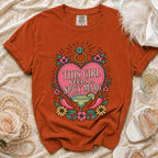 Orange t-shirt with "This girl needs a spicy marg" graphic.