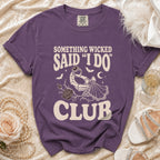 Purple t-shirt with text "SOMETHING WICKED SAID 'I DO' CLUB" and skeleton hand graphic.