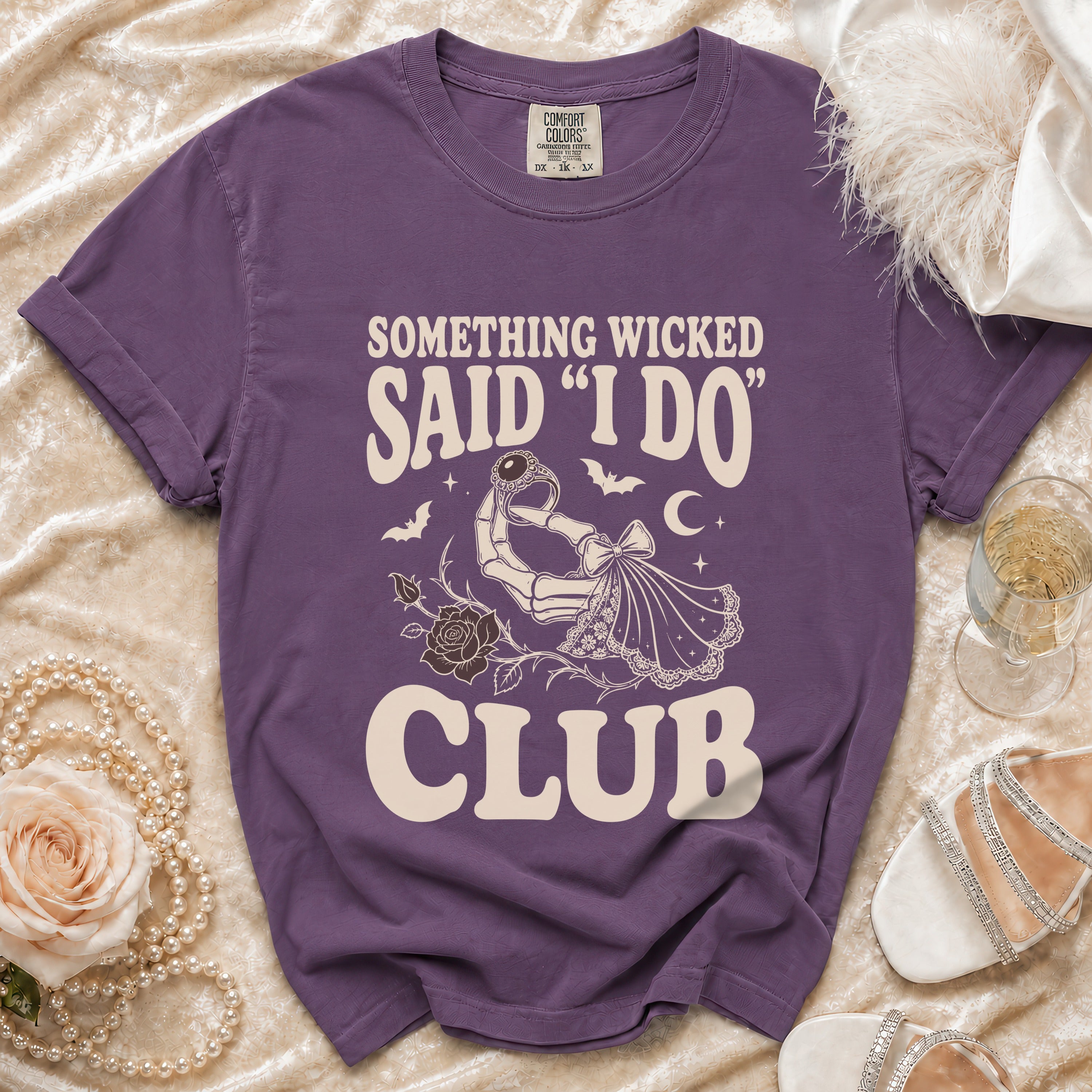 Purple t-shirt with text "SOMETHING WICKED SAID 'I DO' CLUB" and skeleton hand graphic.