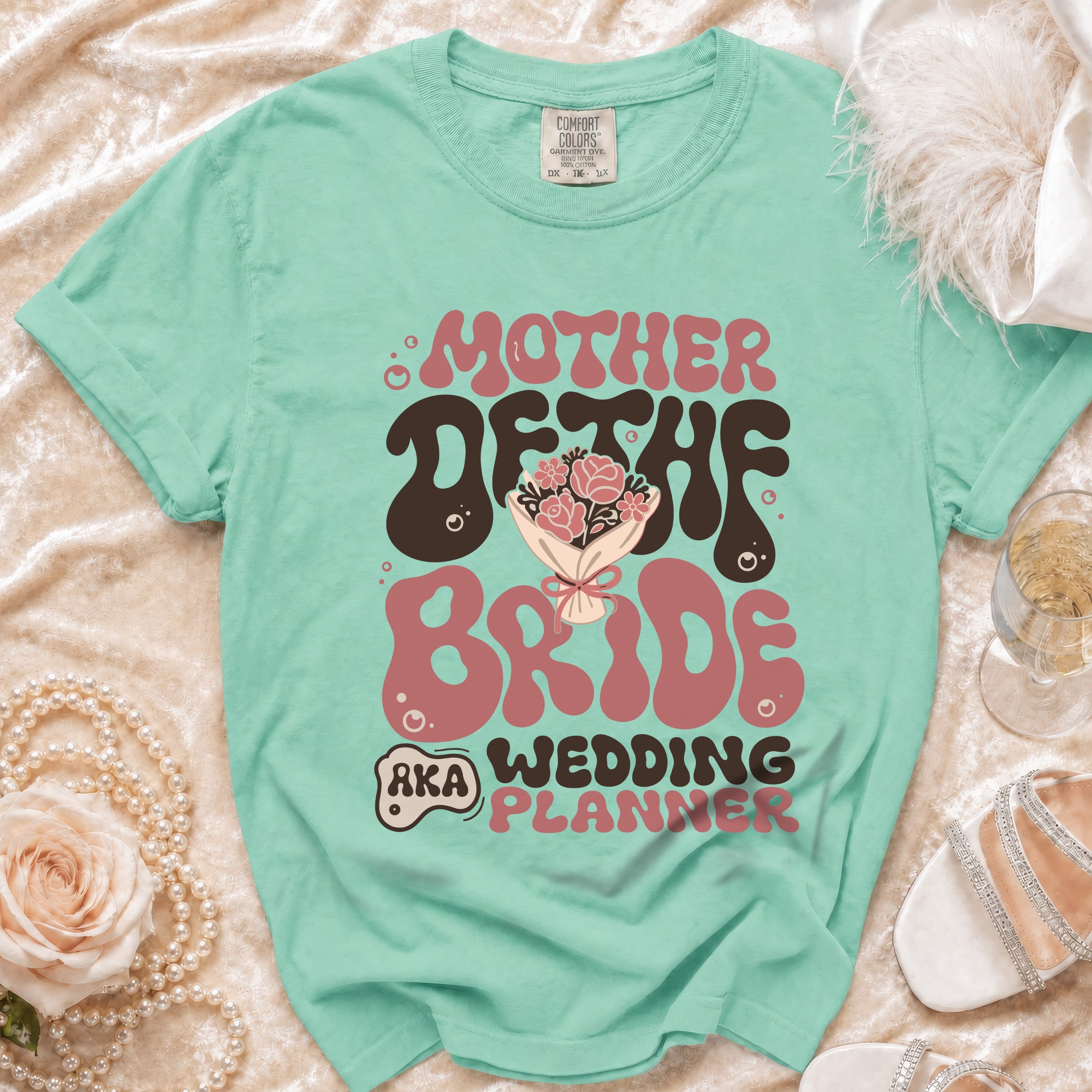 Teal t-shirt with "MOTHER OF THE BRIDE AKA WEDDING PLANNER" graphic.