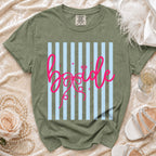 Green t-shirt with pink "bride" text on a light blue striped background.