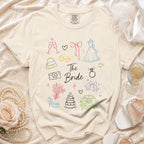 Unisex beige t-shirt with outline graphics of wedding items and "The Bride" text.
