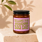 Amber candle with black lid and pink label that reads "Welcome to my breakdown big day".
