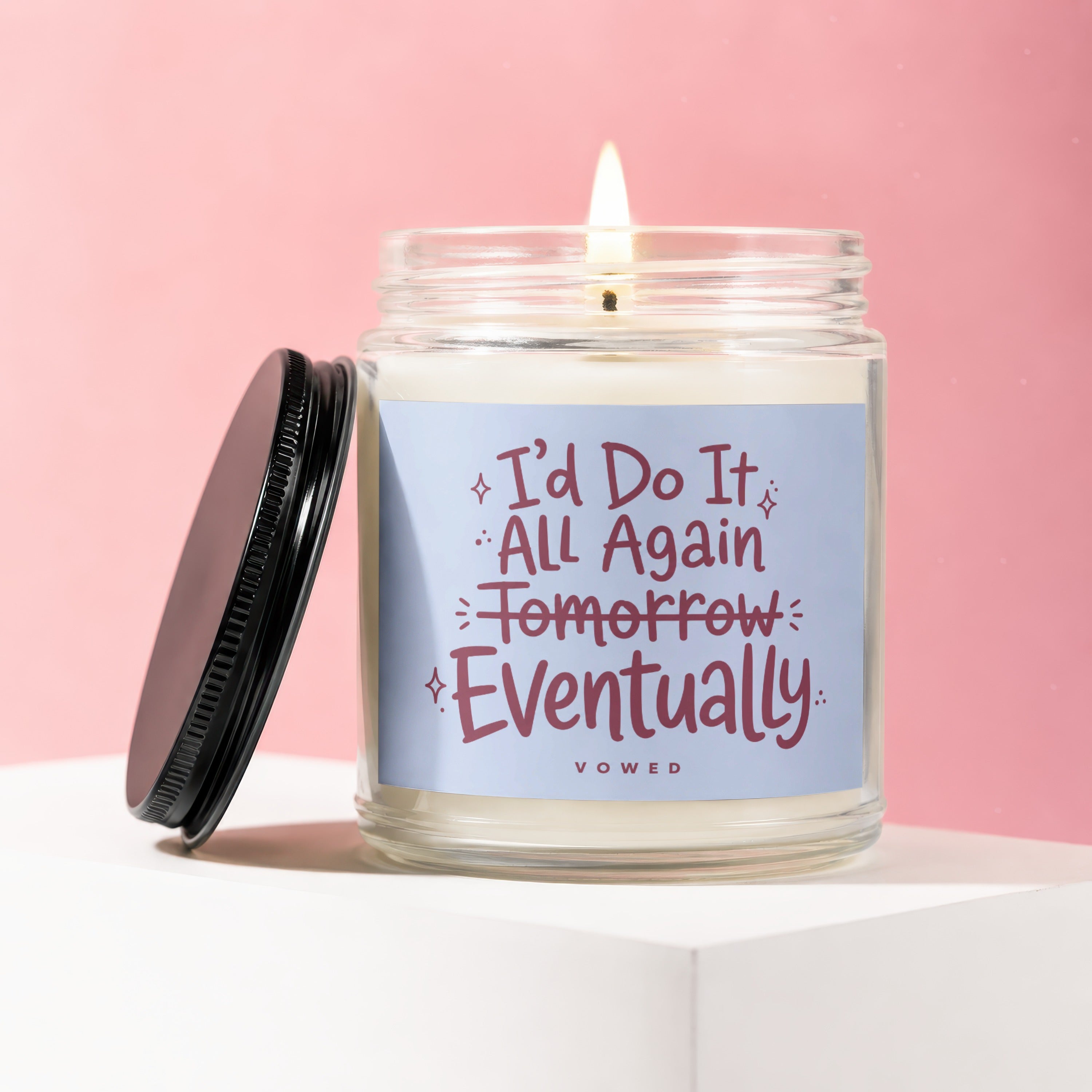 Candle with text "I'd Do It All Again Tomorrow Eventually" on a blue label.