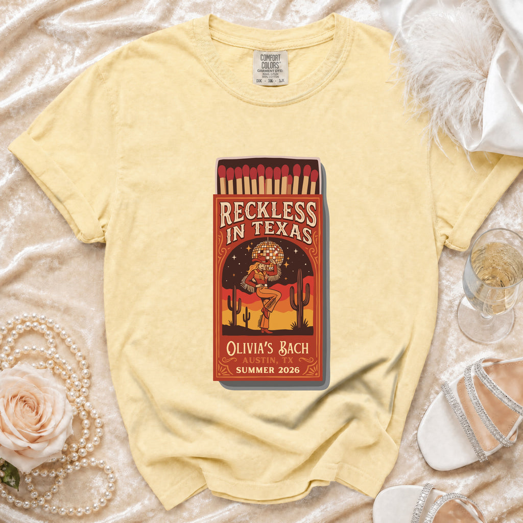 Yellow t-shirt with "Reckless in Texas" matchbox graphic, Olivia's Bach, Austin, TX Summer 2026.