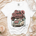 White t-shirt with graphic of couple in a convertible, "Just Hitched & Unsupervised."