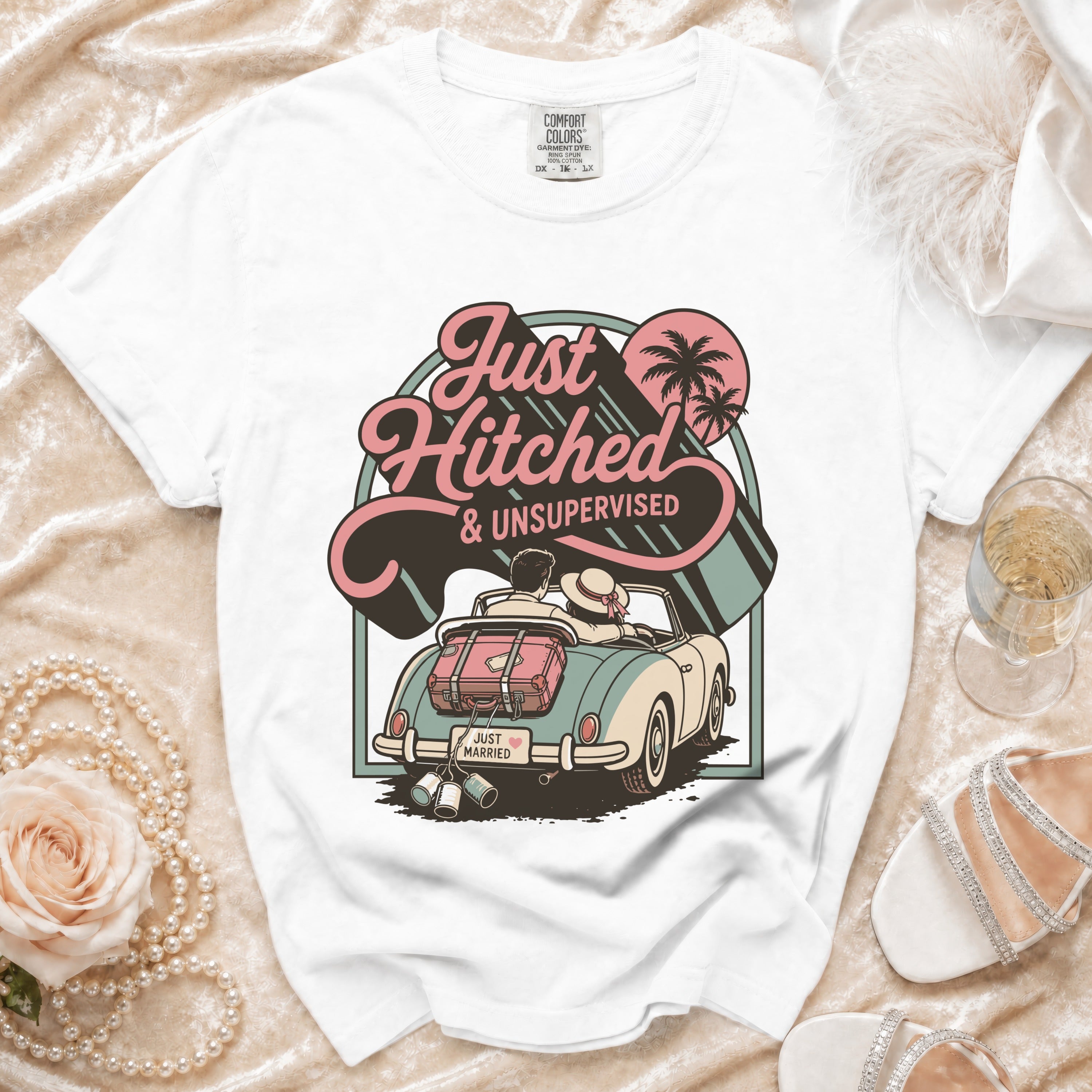 White t-shirt with graphic of couple in a convertible, "Just Hitched & Unsupervised."