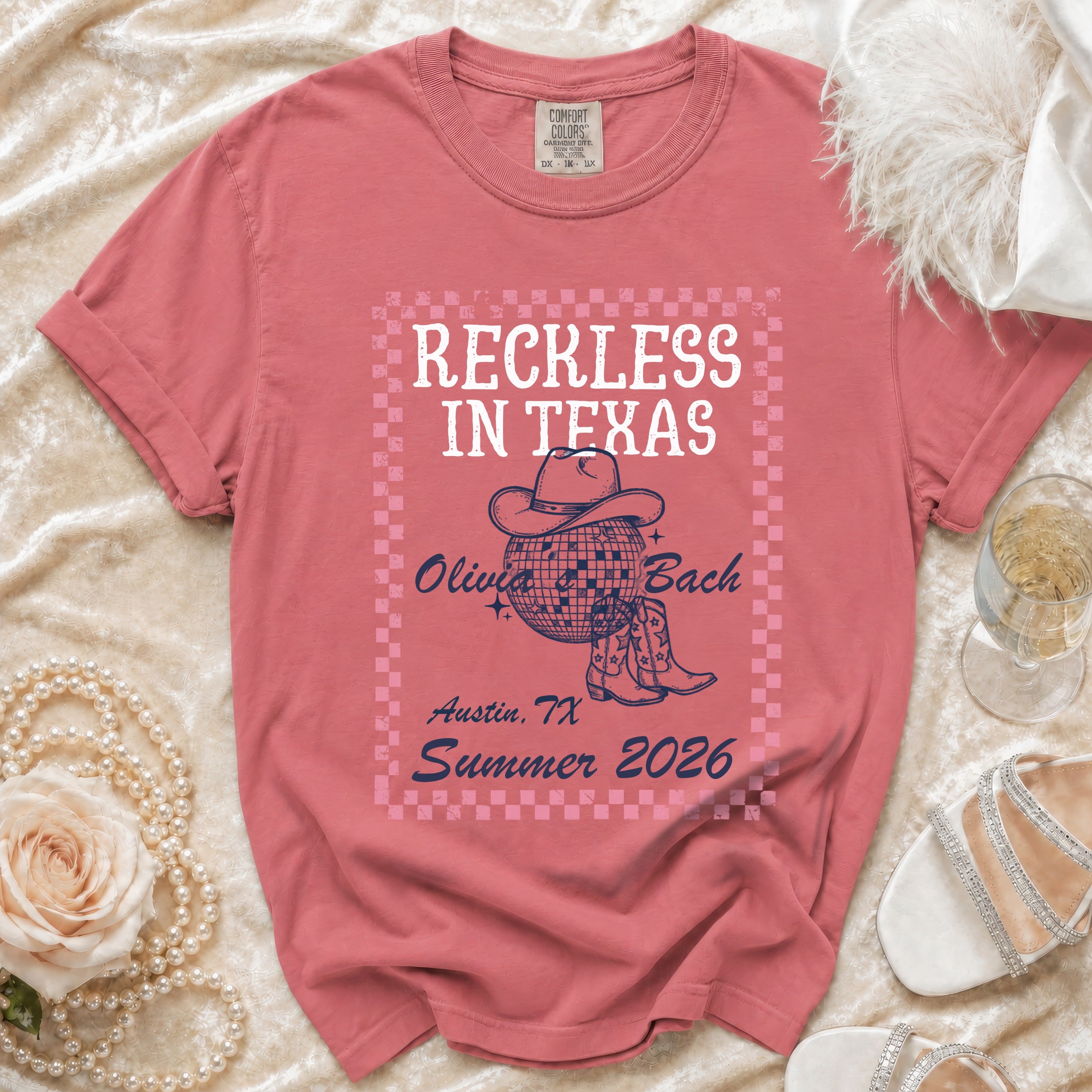 Pink t-shirt with "Reckless In Texas Olivia Bach Austin, TX Summer 2026" graphic.