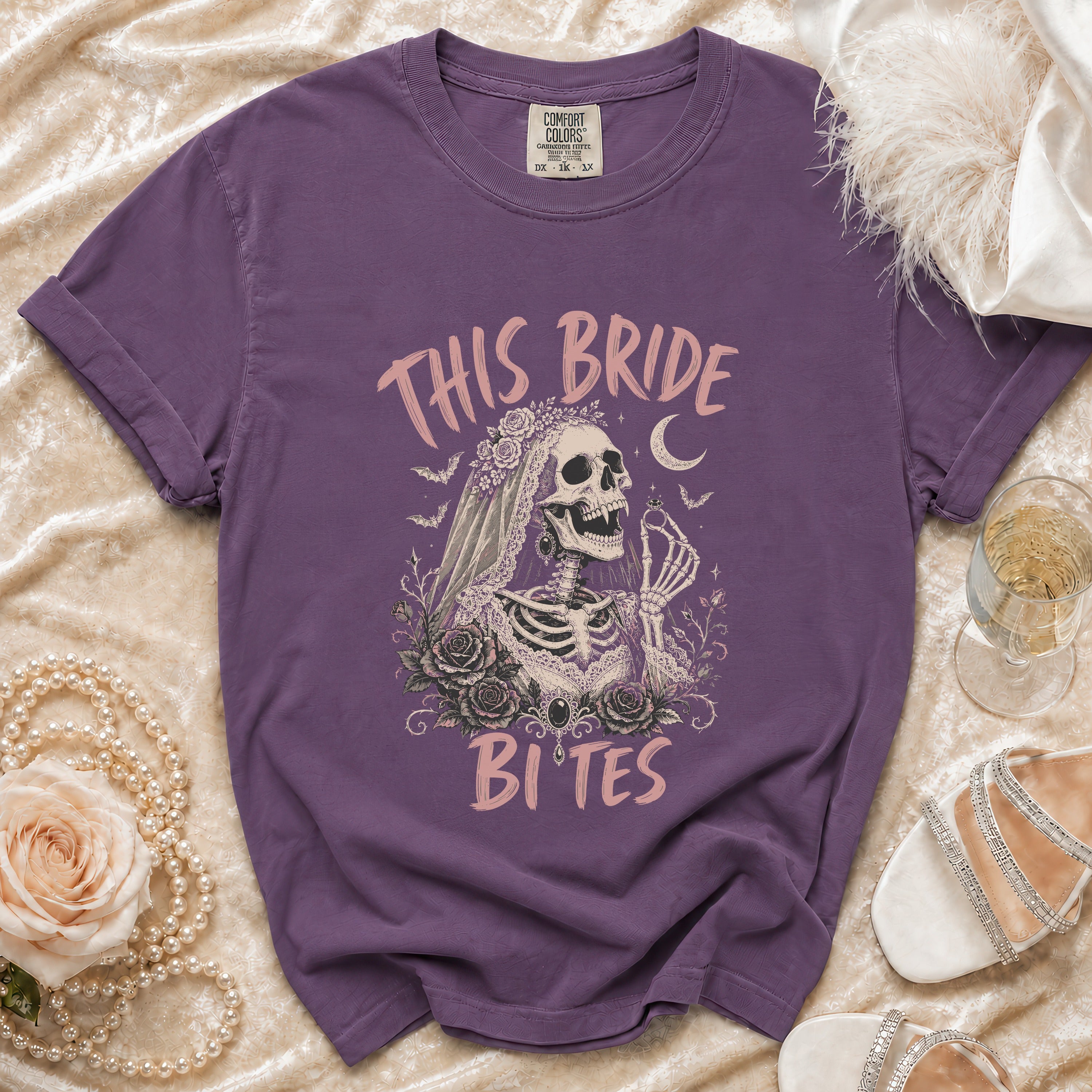 Purple t-shirt with skeleton bride graphic reading "This Bride Bites."